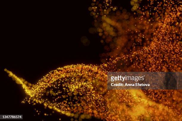 splash of many little orange particles on black background. perfect backdrop for your design - yellow smoke stock pictures, royalty-free photos & images