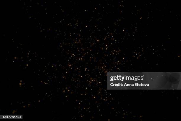 many festive golden dust on black background. concept of new year or birthday celebration. perfect backdrop for your design - spolverare foto e immagini stock