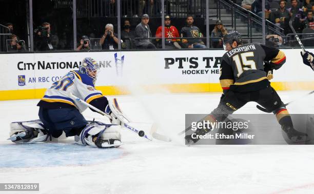 Jordan Binnington of the St. Louis Blues makes a save as Jake Leschyshyn of the Vegas Golden Knights looks for a rebound in the second period of...