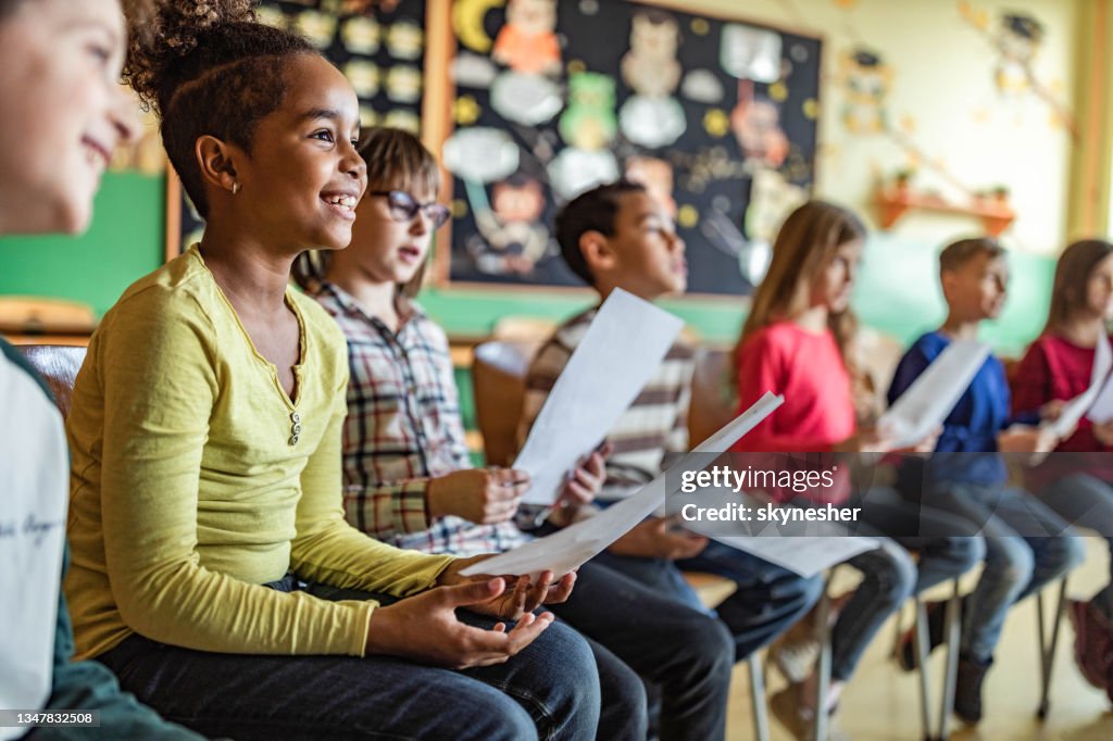 School kids practicing with sheet music on a class at school.