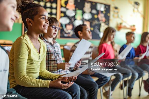 school kids practicing with sheet music on a class at school. - choir imagens e fotografias de stock