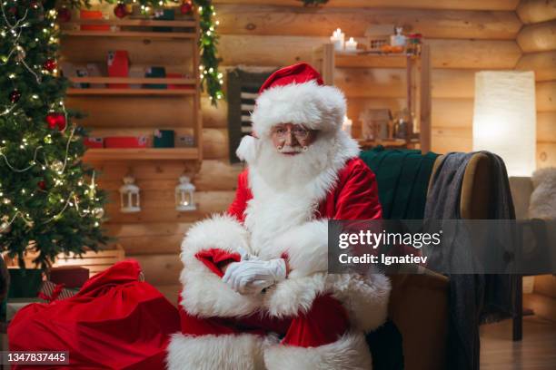 a tired, gloomy santa claus is sitting in an armchair, leaning on his knees - santa leaning stock pictures, royalty-free photos & images