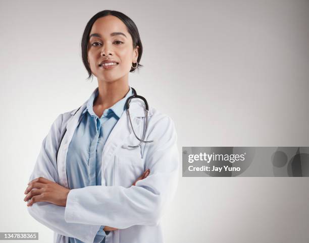 shot of medical practitioner smiling while standing against a grey background - confidence studio shot stockfoto's en -beelden