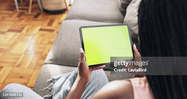 自宅で彼女のタブレットを使用して認識できない女性のショット - using digital tablet ストックフォトと画像