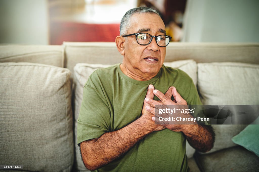 Shot of a senior man holding his chest in pain