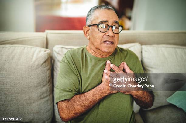 shot of a senior man holding his chest in pain - male chest stock pictures, royalty-free photos & images