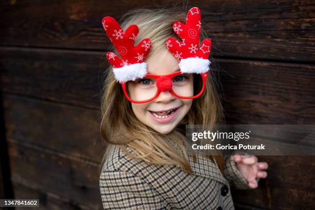 bambina che indossa divertenti occhiali natalizi - blonde glasses foto e immagini stock