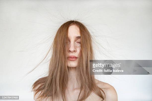 serene woman with electrified hair on white background - haar stockfoto's en -beelden
