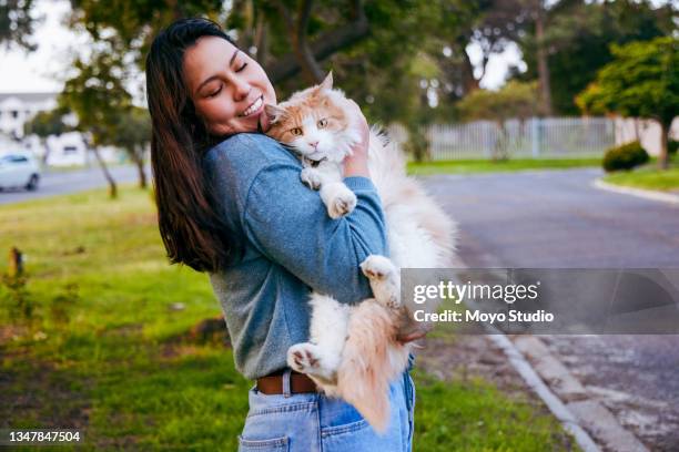 shot of a young woman bonding with her cat outside - pet owner cat stock pictures, royalty-free photos & images