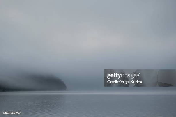 lake in a dense fog in the morning - lake reflection stock pictures, royalty-free photos & images