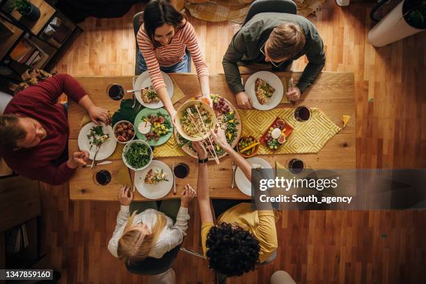 gruppe von freunden essen zusammen - esstisch stock-fotos und bilder