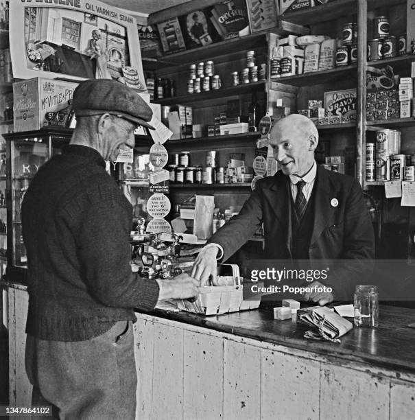 James Lyon, owner of the village grocery store, serves a customer at his shop in the coastal village of Johnshaven in Kincardineshire , Scotland...