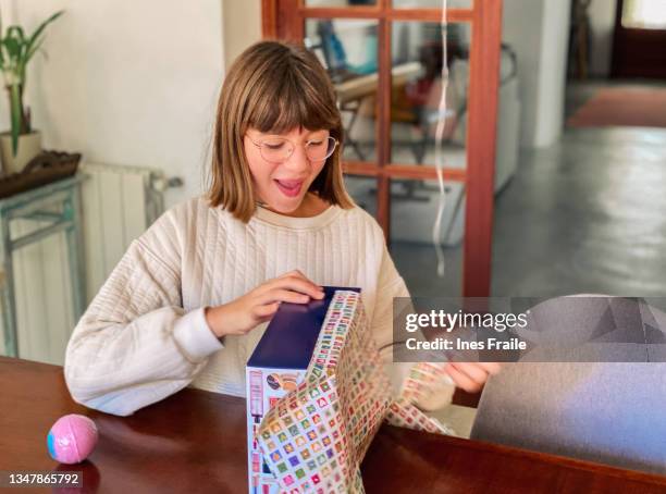 teenager-mädchen, das ein geburtsgeschenk öffnet - teen birthday stock-fotos und bilder