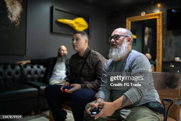 customers playing video games at the barber shop - salon tv stock pictures, royalty-free photos & images