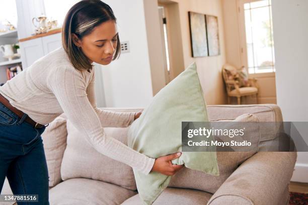 photo d’une belle jeune femme rangeant les coussins de dispersion sur son canapé - cushion photos et images de collection