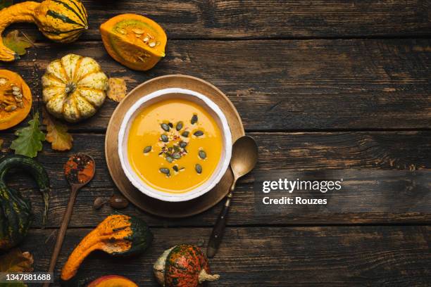 kürbissuppe mit zutaten auf rustikalem holztisch - pumpkin soup stock-fotos und bilder