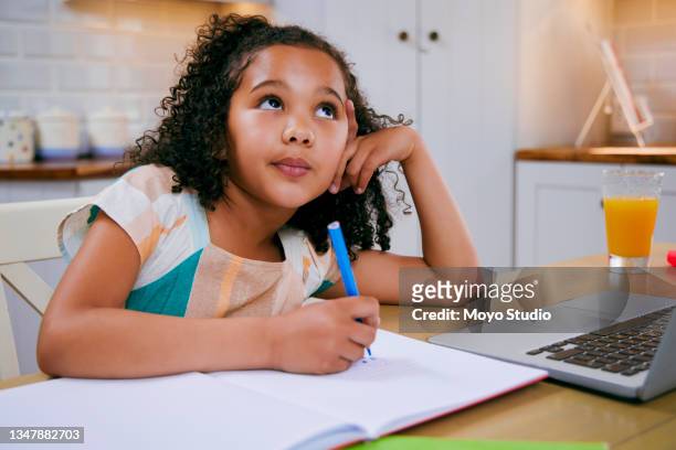 photo d’une petite fille rêvassant tout en faisant ses devoirs - sad girl drawing photos et images de collection