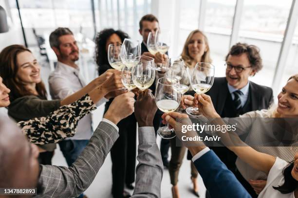 geschäftskollegen stoßen bei der arbeit an - celebratory toast stock-fotos und bilder