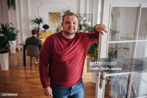 porträt eines jungen mannes zu hause - fat guy stock-fotos und bilder
