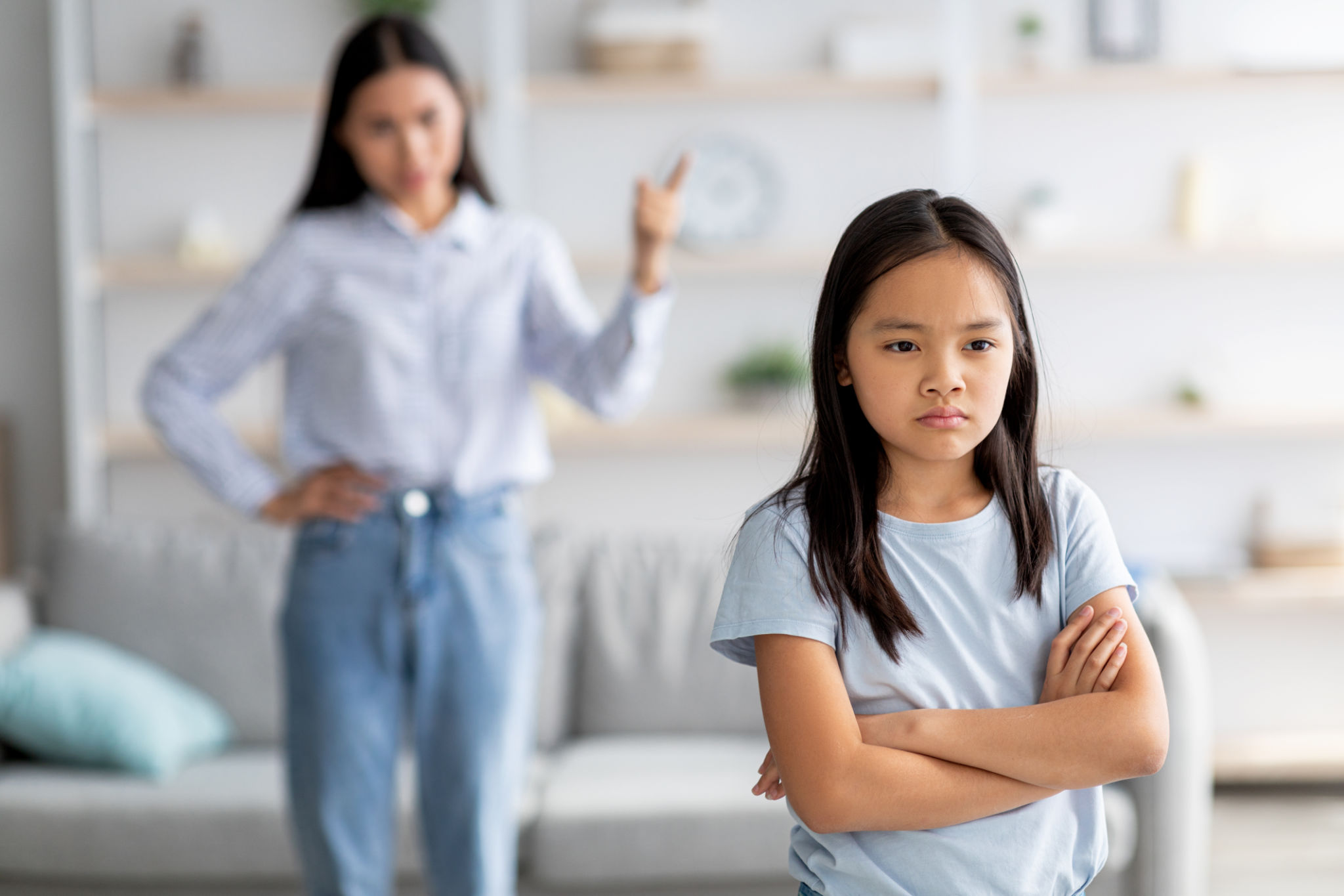 Family conflict. Mother and daughter quarreling at home, girl ignoring her mom, standing back to her with crossed arms Family conflict. Mother and daughter quarreling at home, girl ignoring her mom, standing back to her with crossed arms