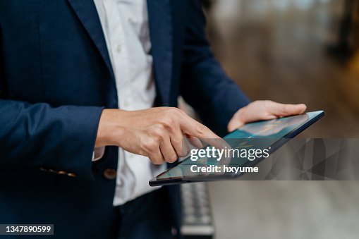 Asian businessman checking stock market chart on digital tablet Asian businessman checking stock market chart on digital tablet