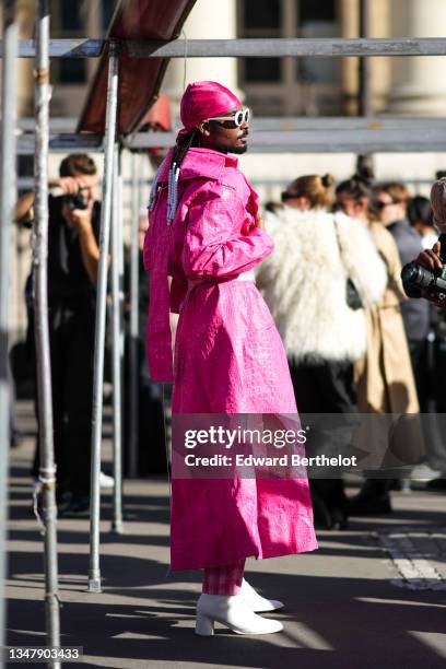 Guest wears white sunglasses, a pink fuchsia scarf on the hair, silver earrings, silver rings, a neon pink fuchsia leather crocodile pattern long...