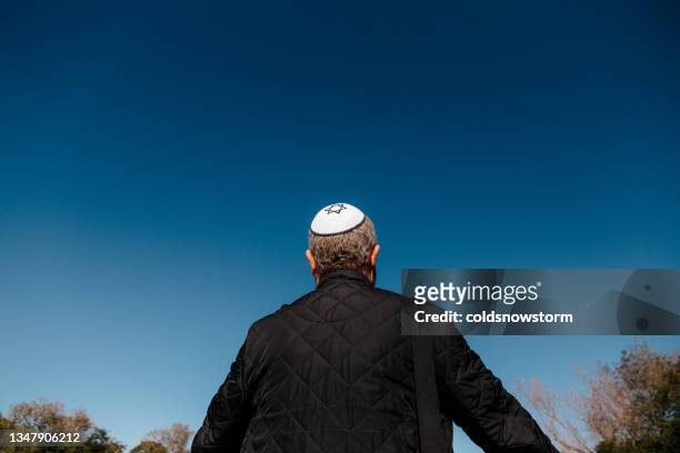 rear view of jewish man wearing skull cap looking at blue sky - 猶太教 個照片及圖片檔