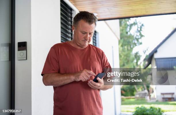 getting the playlist lined up for his run - eastern european man in front of house stock pictures, royalty-free photos & images