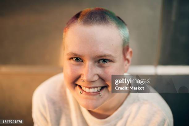 portrait of smiling young transgender man with nose and lip piercings - transgender stock pictures, royalty-free photos & images