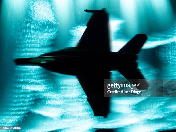 army aircraft flying at high speed at night through the clouds on a war or military exercise mission. - air force stock-fotos und bilder