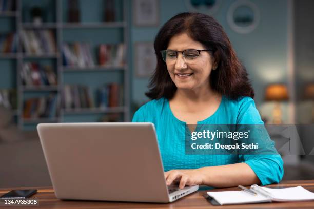 frau, die von zu hause aus auf dem laptop arbeitet, stockfoto - indian old woman stock-fotos und bilder