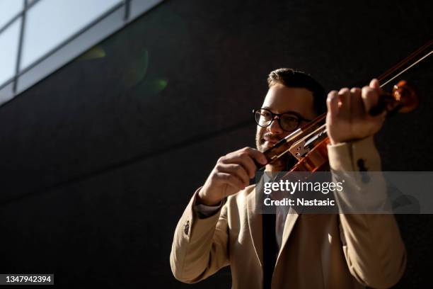 uomo ben vestito che suona il violino - violinist foto e immagini stock