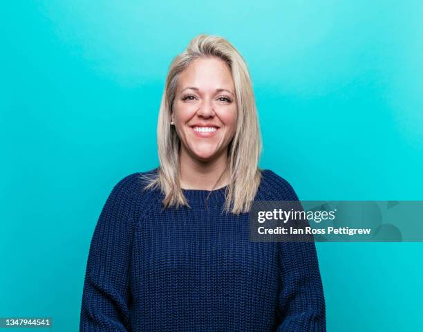 beautiful woman smiling, blue background - mujer feliz sola 30 35 fotografías e imágenes de stock