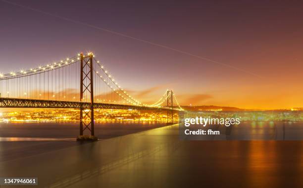 ponte 25 de abril at sunset(bridge of april 25) - lisbon, portugal - 25 de abril bridge stockfoto's en -beelden