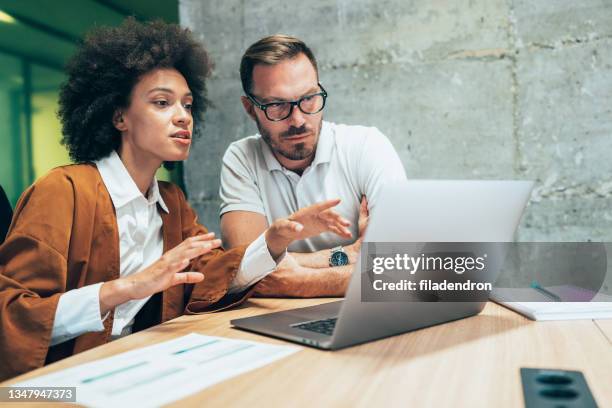 two business people working together in office - colleague discussion stock pictures, royalty-free photos & images