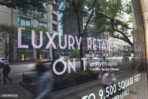 Pedestrians walk past a vacant storefront along the Magnificent Mile shopping district on October 21, 2021 in Chicago, Illinois. Retailers are moving...