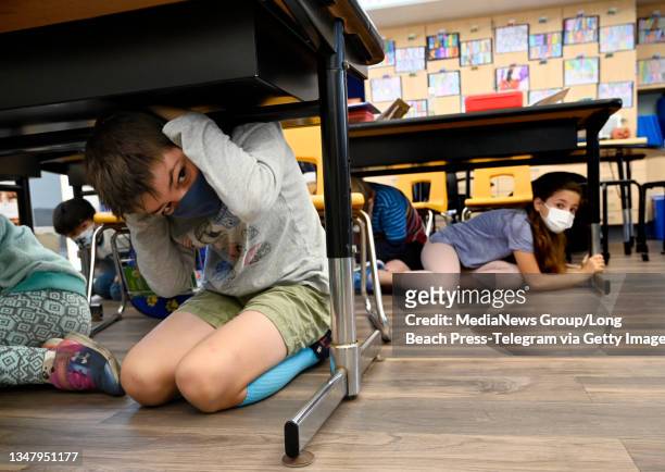 Third grade students in Mrs. Jordan"u2019s class under their desks as they participate in the Great Shakeout at Pacific Elementary School in...