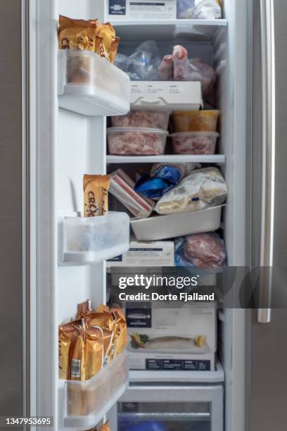 a look into a very full freezer - fridge full of food stockfoto's en -beelden