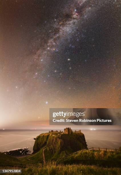 milky way over dunnottar castle, scotland - schottland stock-fotos und bilder