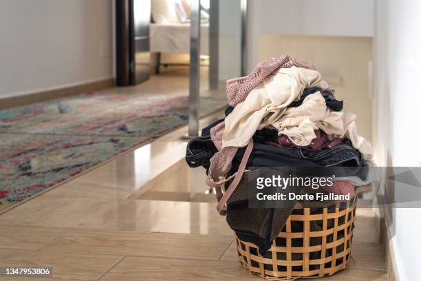 basket with laundry on a tiled floor - laundry basket fotografías e imágenes de stock