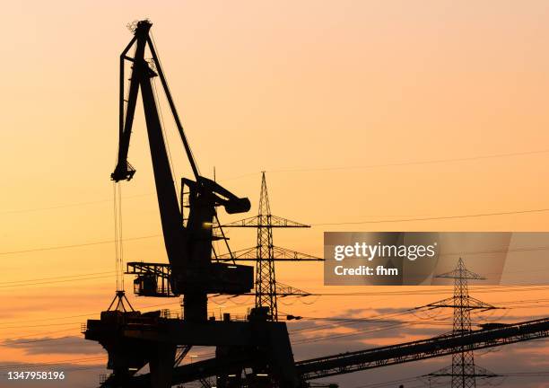 coal crane and electricity pylons at sunset - rhineland palatinate stockfoto's en -beelden