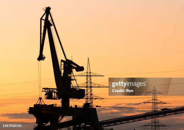 coal crane and electricity pylons at sunset - rhineland palatinate stock pictures, royalty-free photos & images