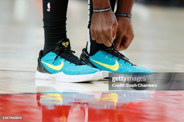 Buddy Hield of the Sacramento Kings adjusts his shoe against the Portland Trail Blazers during the first quarter at Moda Center on October 20, 2021...