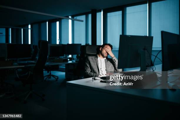 joven empresario cansado por la noche - burnout fotografías e imágenes de stock