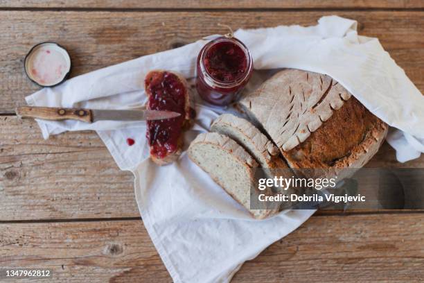 mermelada de ciruela unta en rebanada de pan integral sobre un fondo rústico - butter making fotografías e imágenes de stock