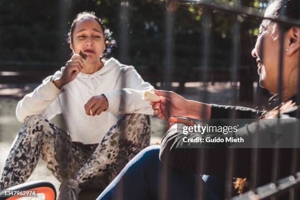 woman and friend eating healthy snack after training outdoor. - food court stock-fotos und bilder