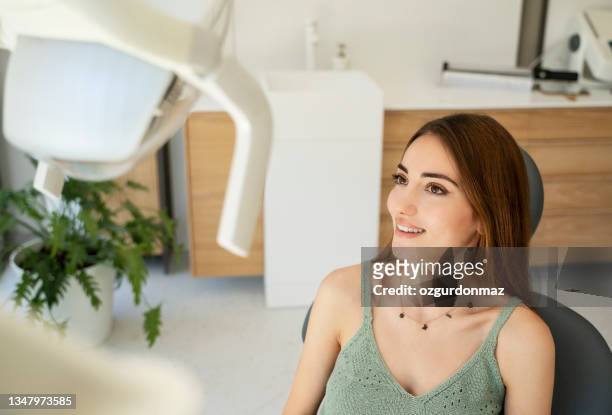 paciente do sexo feminino olhando no espelho e verificando os dentes após o tratamento - implante dentário - fotografias e filmes do acervo
