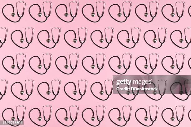black stethoscopes pattern on pink background. - stethoskop stock-fotos und bilder