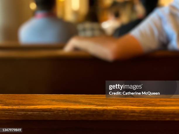 rear view of pews with unrecognizable people sitting - mis stockfoto's en -beelden