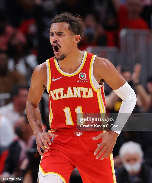 Trae Young of the Atlanta Hawks reacts assisting on a dunk by Clint Capela against the Dallas Mavericks during the first half at State Farm Arena on...